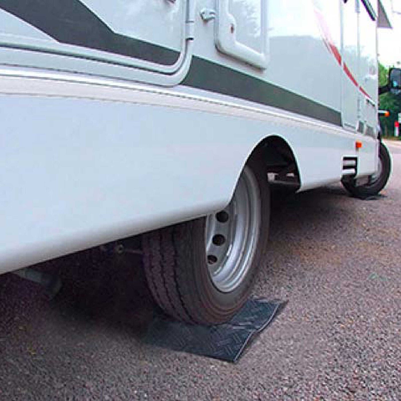 a black concave-shaped TyreGuard® tyre protector made of high-strength plastics, underneath a light-blue recreational vehicle