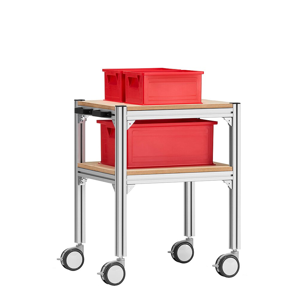 a small trolley made of aluminium profiles, with two storeys, wooden inlay shelvings, black pushbar handle made of plastics, four large, fastenable & turnable wheels and three red EURO stackable boxes, isolated on white background