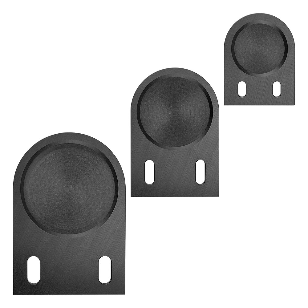 three differently-sized black floor-fixture plates for levelling elements, with elongated holes for floor-anchoring, made of precision-milled composite material, in the flat-lay view from above, isolated on white background